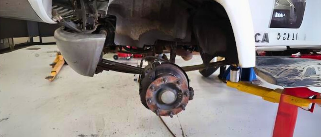 Signs you need brake repair in Morgan Hill, CA with C&M Auto Service. Image of worn out brakes on fleet vehicle that is on lift in shop bay