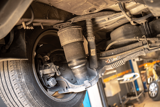 Suspension repair shop near me in Morgan Hill, CA with C&M Auto Service. Image of car suspension system on a vehicle on lift in the shop that came in for suspension issues.