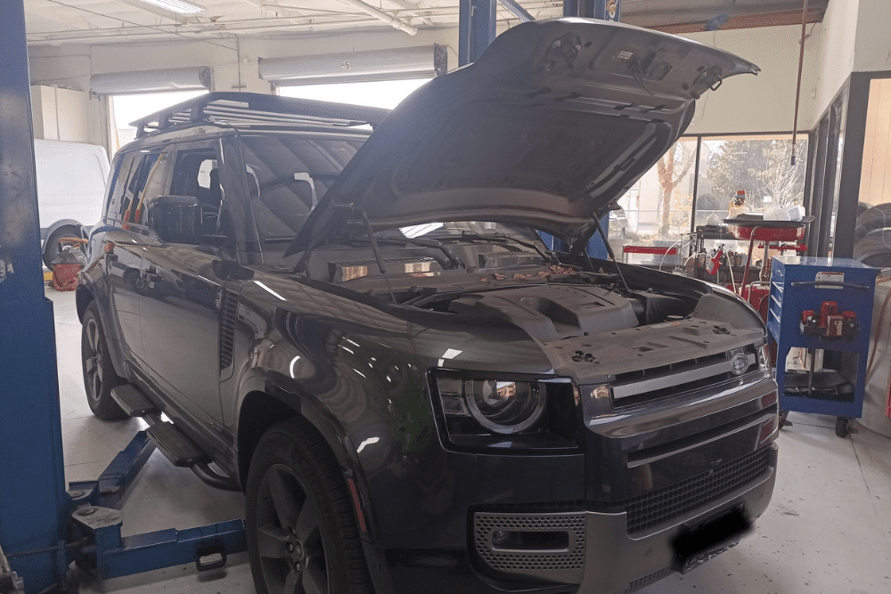 Car Inspections in Morgan Hill, CA by C&M Auto Service. Image of a Land Rover Defender in a service bay with the hood open, showcasing the shop’s commitment to expert diagnostics, maintenance, and reliable performance for luxury SUVs.