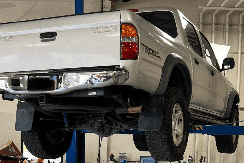 Diesel aftertreatment system repair in Morgan Hill, CA by C&M Auto Service Inc. Image of a Toyota Tacoma lifted on a shop hoist, highlighting professional suspension and undercarriage service to ensure performance and safety.
