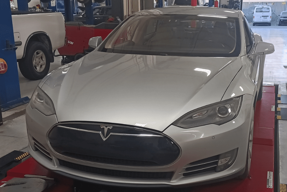 EV and hybrid maintenance in Morgan Hill, CA by C&M Auto Service, Inc. Image of a Tesla on a shop lift ready for maintenance. Highlighting C&M Auto Service Inc.’s commitment to advanced EV care and reliable electric vehicle performance.