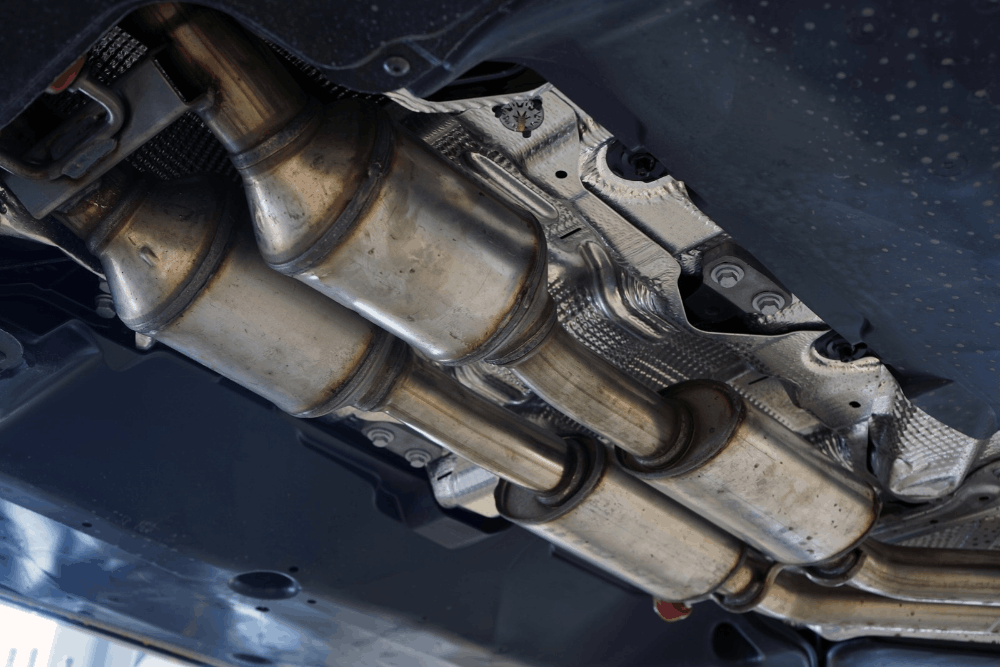 Catalytic converter repair by C&M Auto Service Inc. Image of catalytic converters and exhaust piping beneath a vehicle during inspection and service in Morgan Hill, CA.